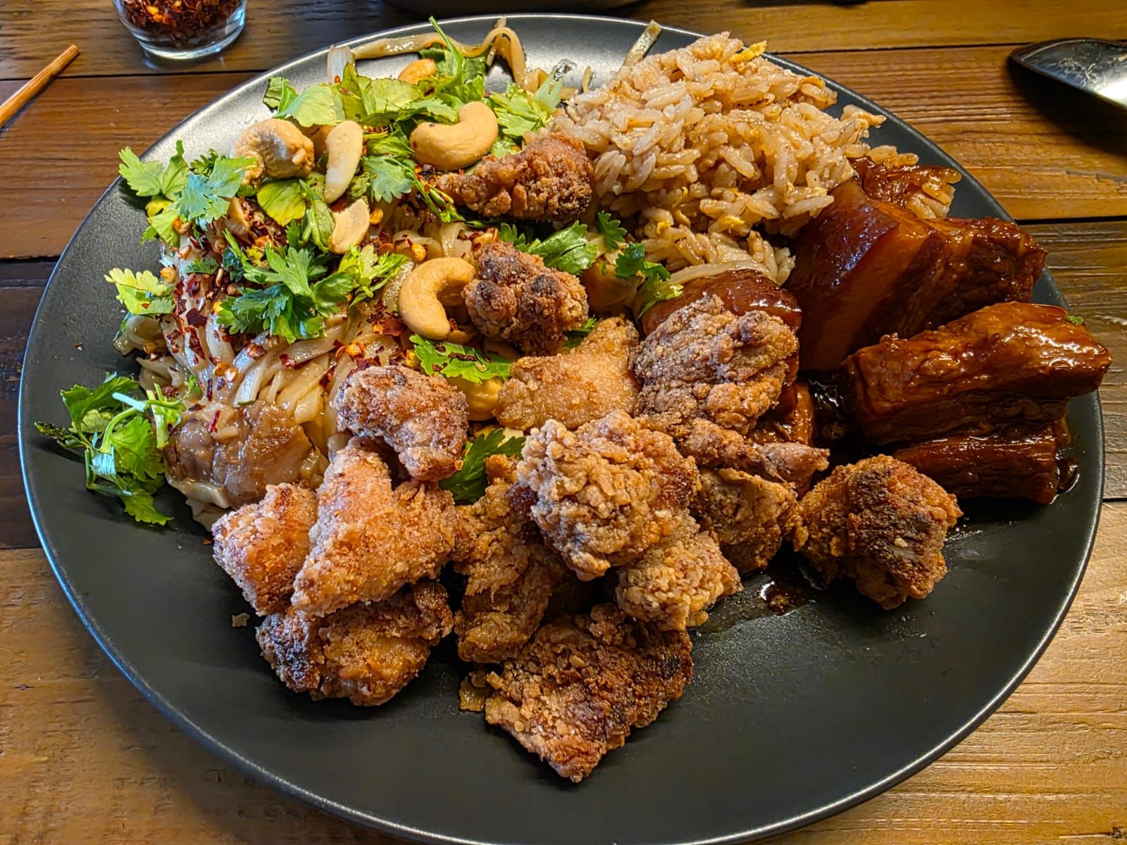 Asiatische Fusion-Platte mit knusprigem Hähnchen, glasiertem Schweinebauch und Fried Rice