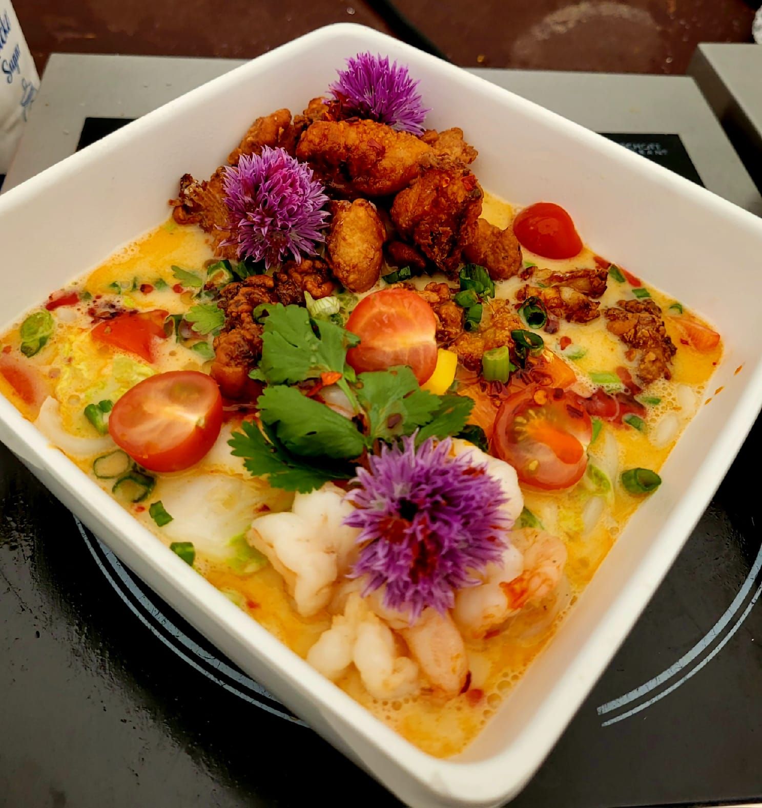 Thai-Curry-Bowl mit Garnelen, knusprigem Hähnchen und essbaren Blüten
