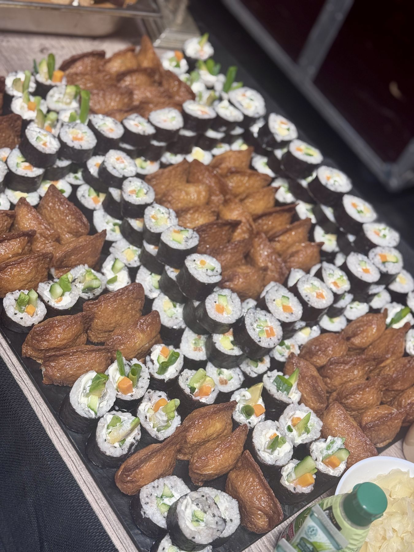 Sushi-Rollen und Inari-Taschen, kunstvoll auf einer Platte angerichtet
