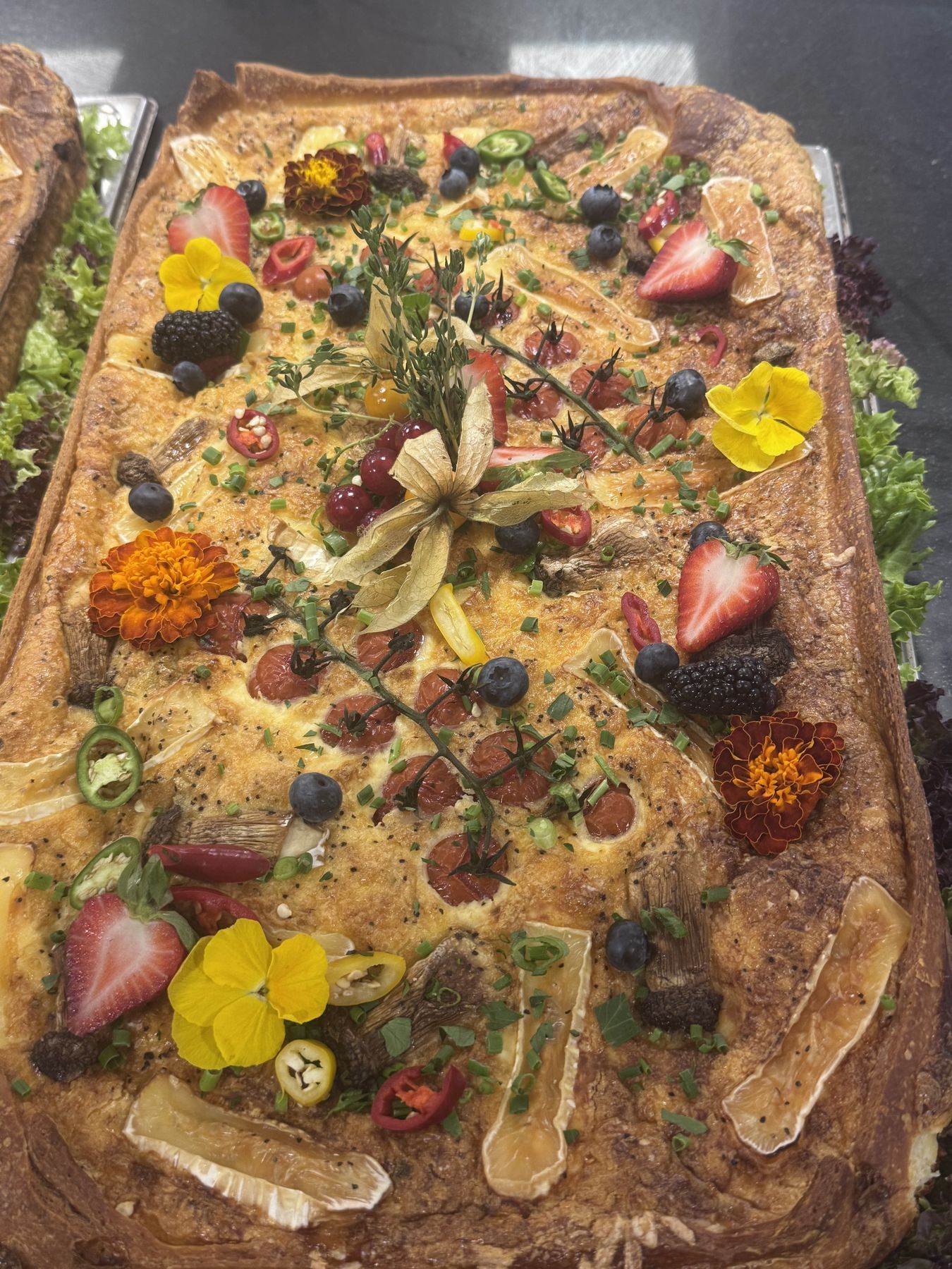 Kunstvoll angerichtete Blätterteig-Tarte mit essbaren Blüten und Beeren, We Love Cooking Catering
